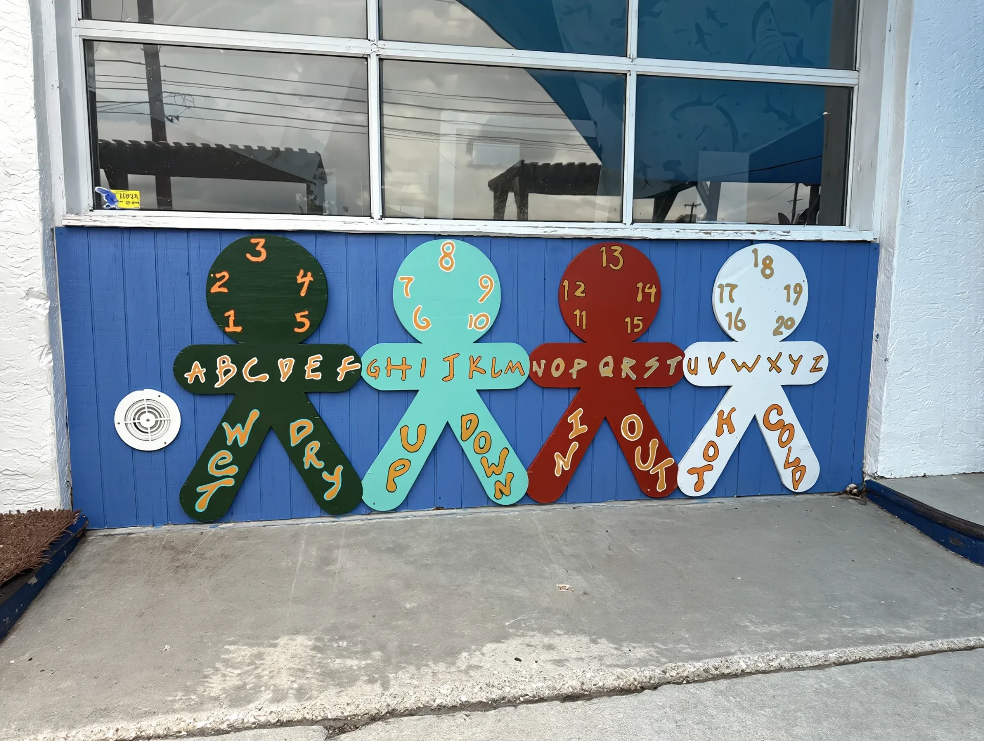 Hands-on learning wall painted with the alphabet, numbers 1–20, and opposite-word figures